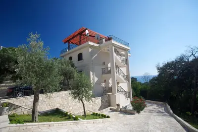 a white building with a red roof at St.George Apartments in Petrovac na Moru