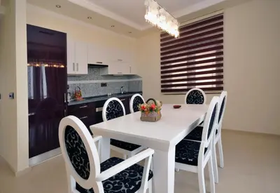 a kitchen and dining room with a white table and chairs at St.George Apartments in Petrovac na Moru