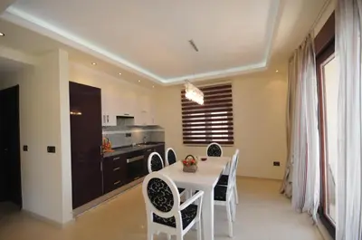 a dining room with a table and chairs and a kitchen at St.George Apartments in Petrovac na Moru