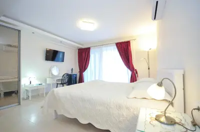 a bedroom with a white bed and a window at St.George Apartments in Petrovac na Moru