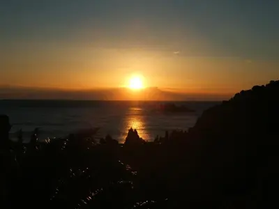 a sunset over the ocean with the sun in the sky at St.George Apartments in Petrovac na Moru