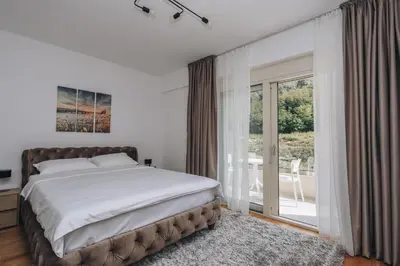 a bedroom with a large bed and a balcony at Status-M Apartments 174 in Becici