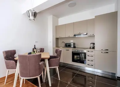 a kitchen and dining room with a table and chairs at Status-M Apartments 174 in Becici
