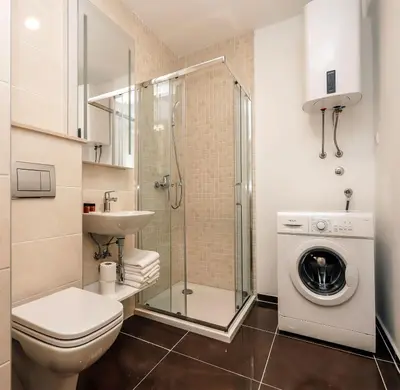 a bathroom with a toilet sink and a washing machine at Status-M Apartments 174 in Becici