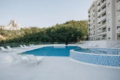 a swimming pool with chairs and a building at Status-M Apartments 174 in Becici