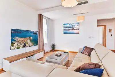a living room with a white couch and a tv at Lux Panorama in Budva