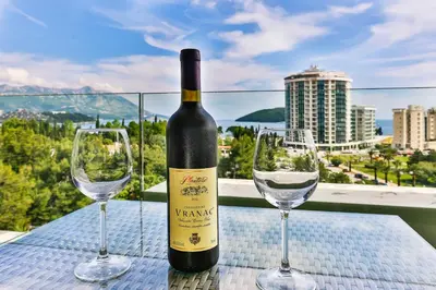 a bottle of wine and two wine glasses on a table at Lux Panorama in Budva