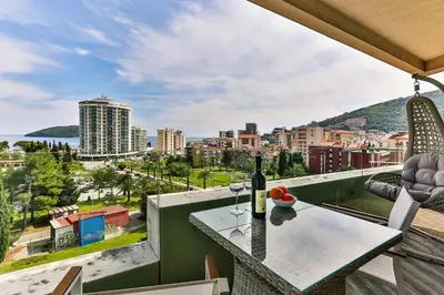 a balcony with a table with a bottle of wine at Lux Panorama in Budva
