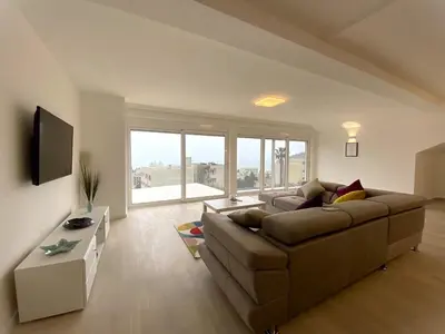 a living room with a couch and a large window at Apartments Marina in Becici