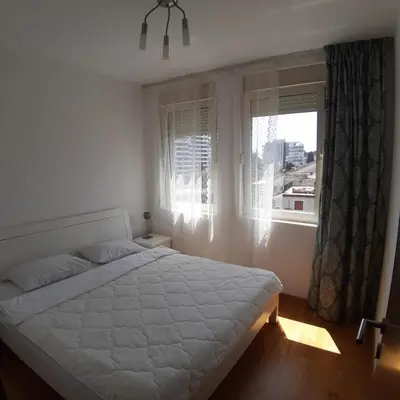 a bedroom with a white bed and a window at City & Sea Apartment nearby Old Town in Budva