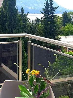 a balcony with a table and yellow flowers on it at City & Sea Apartment nearby Old Town in Budva