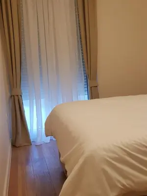 a bedroom with a white bed and a window at Apartman VIVO city central in Podgorica