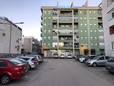 a parking lot with cars parked in front of a building at Apartment Center Adria in Bar