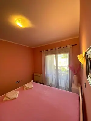 a bedroom with a pink bed and a window at Apartment Center Adria in Bar