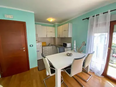 a kitchen and dining room with a table and chairs at Apartment Center Adria in Bar