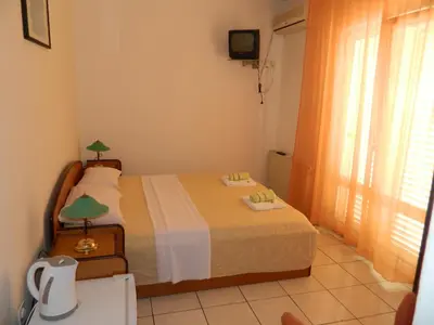 a bedroom with a bed and a window at Mena apartmani in Budva