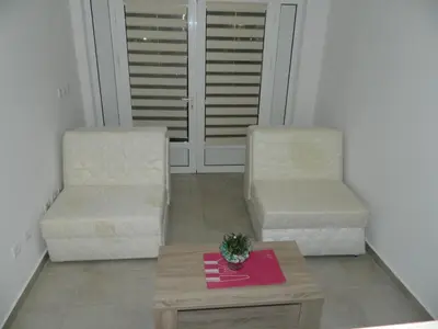 two chairs and a coffee table in a living room at Mena apartmani in Budva