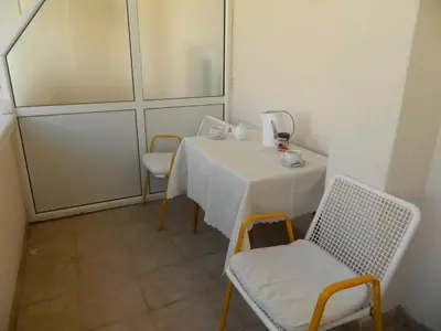 a white table and chairs in a room with a window at Mena apartmani in Budva