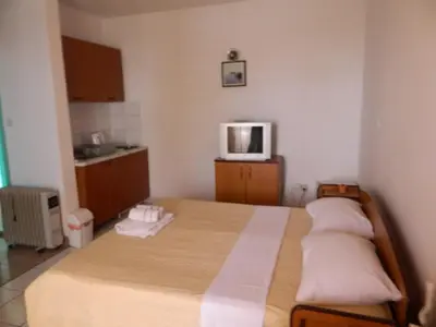a bedroom with a bed and a tv on the wall at Mena apartmani in Budva