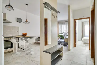 a kitchen and living room with a table and chairs at Ada apartman in Budva