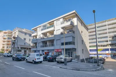 a parking lot with cars parked in front of a building at Ada apartman in Budva