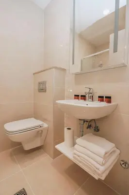 a white bathroom with a sink and a toilet at Status-M Аpartments 173 in Becici