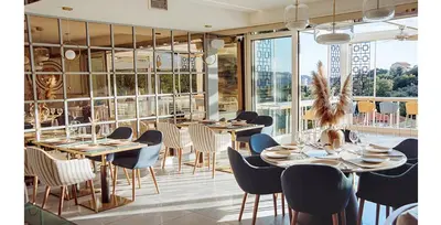 a dining room with tables and chairs and windows at Status-M Аpartments 173 in Becici