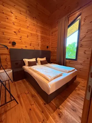 a bedroom with a bed in a wooden room at Ada Bojana Beach House I XXL TerraceI BBQ I Betw BridgeBeach I Air Con in Ulcinj