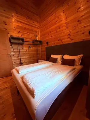 a large bed in a room with wooden walls at Ada Bojana Beach House I XXL TerraceI BBQ I Betw BridgeBeach I Air Con in Ulcinj