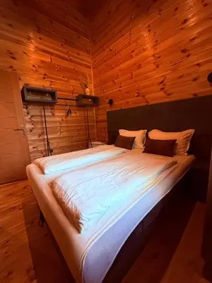 a large bed in a room with wooden walls at Ada Bojana Beach House I XXL TerraceI BBQ I Betw BridgeBeach I Air Con in Ulcinj