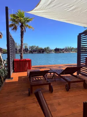 a deck with two picnic tables and a palm tree at Ada Bojana Beach House I XXL TerraceI BBQ I Betw BridgeBeach I Air Con in Ulcinj