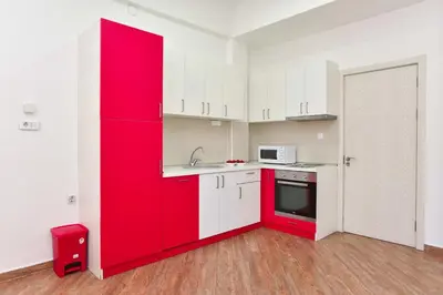 a red kitchen with white cabinets and a red refrigerator at Victoria Center Apartments in Budva