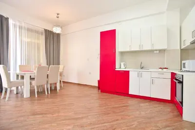a kitchen and dining room with red and white cabinets at Victoria Center Apartments in Budva