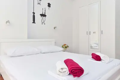 a white bed with towels on top of it at Victoria Center Apartments in Budva