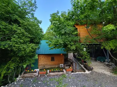 a log cabin with a green roof and a tree at Brvnara Fairy Tale in Cetinje