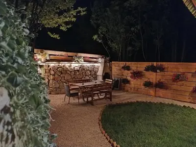 a table and chairs in a backyard at night at Brvnara Fairy Tale in Cetinje