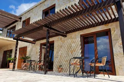 a patio with chairs and tables under a wooden pergola at Peaceful Sea Residence in Bigovo