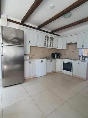 a kitchen with white cabinets and a stainless steel refrigerator at Peaceful Sea Residence in Bigovo