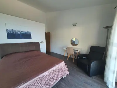 a bedroom with a bed and a chair at Peaceful Sea Residence in Bigovo
