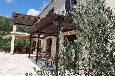 a building with a table and chairs on a patio at Peaceful Sea Residence in Bigovo
