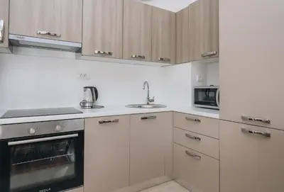 a kitchen with white cabinets and a sink at Status-M Apartments 179 in Becici