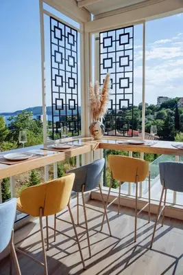 a dining room with a table and chairs and large windows at Status-M Apartments 179 in Becici