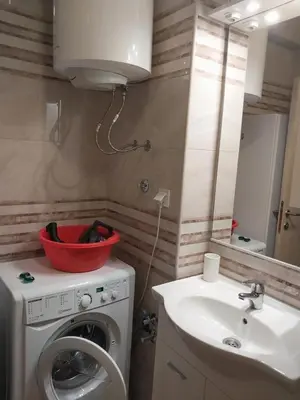 a bathroom with a washing machine and a sink at Bella Costa in Dobra Voda