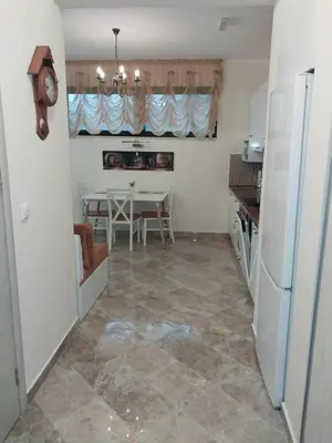 a kitchen and dining room with a table and refrigerator at Bella Costa in Dobra Voda