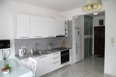 a white kitchen with white cabinets and a sink at Bella Costa in Dobra Voda