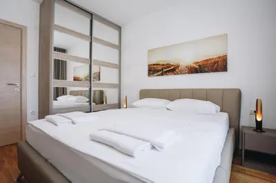 a bedroom with a large white bed with white pillows at Status-M Apartments 205 in Becici