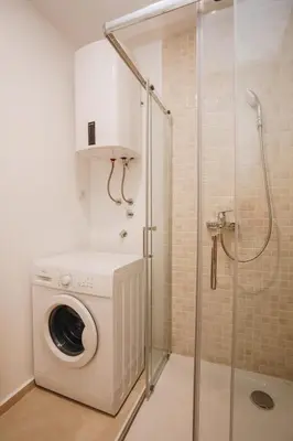 a washing machine in a bathroom with a shower at Status-M Apartments 205 in Becici