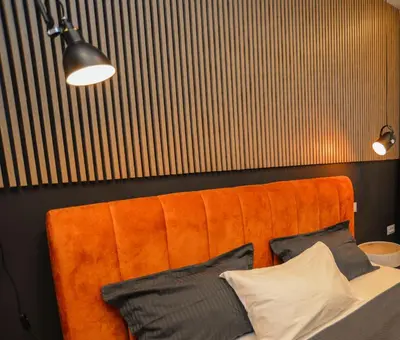 an orange couch in a room with pillows on it at Design Apartment near Gorica Park in Podgorica