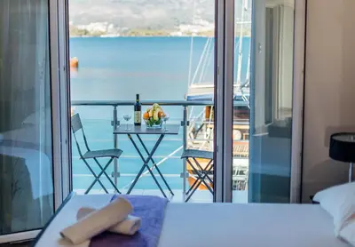 a room with a bed and a table with a view of the ocean at Beachfront Apartments Tivat in Tivat