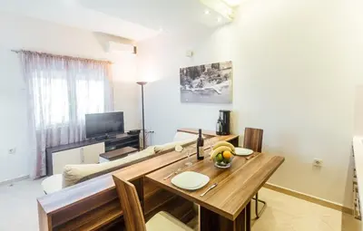 a living room with a table and a couch at Beachfront Apartments Tivat in Tivat